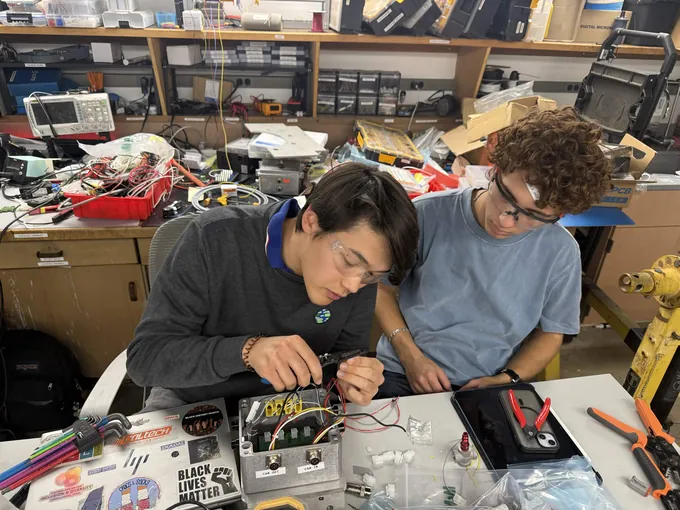 PARSEC members debugging avionics electronics in the lab