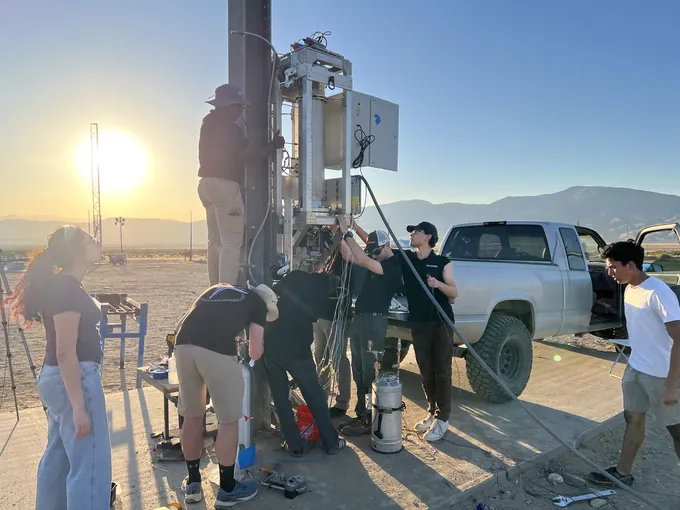 PARSEC members preparing Monolith for a hot fire at sunset